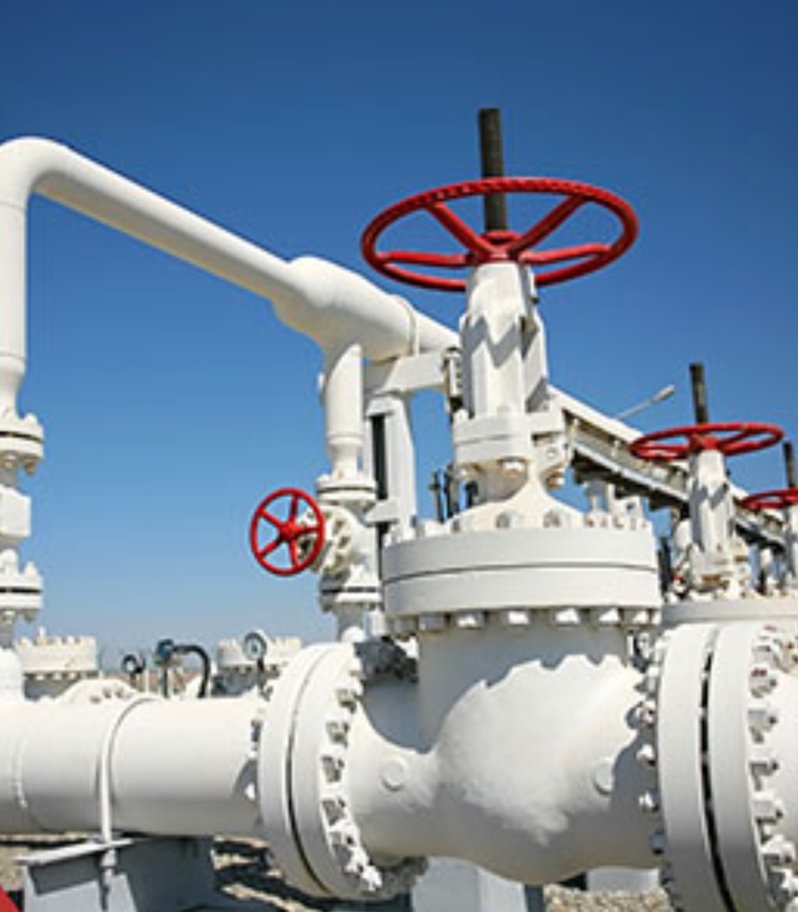 Production valves and flowline pipework under a clear sky